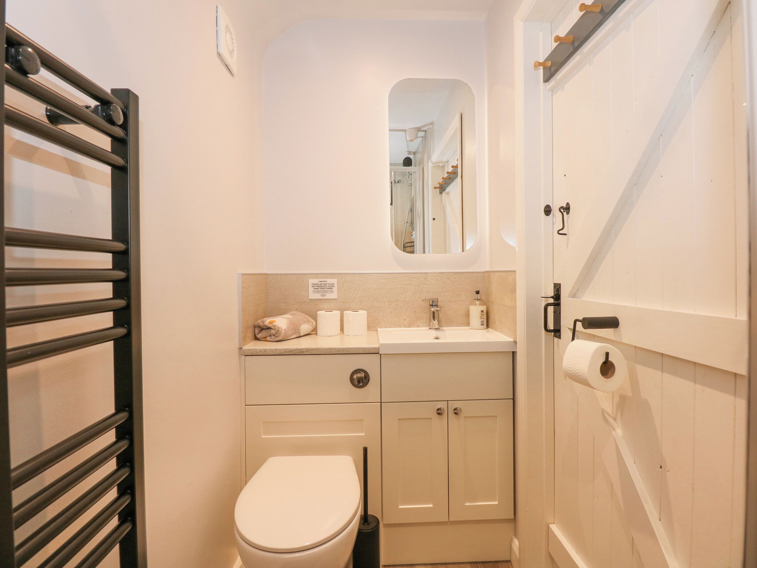Un baño pequeño con inodoro, lavamanos y espejo.