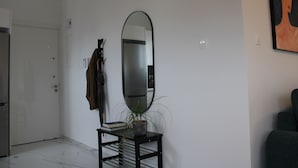 A modern living room with a large mirror, a potted plant, and a bookshelf. - Hypnos Residence (Ayios Dhometios)