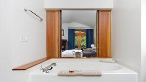 Ein Badezimmer mit großem Spiegel, einer Badewanne und einem Holzwaschtisch.