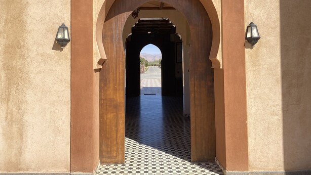 An arched doorway with a checkered floor leading to a street. - IGHIZ INN Resort (Errachidia)