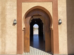 An arched doorway with a checkered floor leading to a street. - IGHIZ INN Resort (Errachidia)