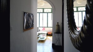 A room with a bed, a table, and a large mirror.