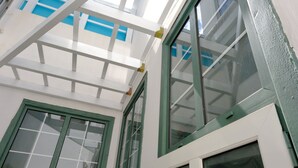 A room with a skylight, large windows, and a white and green color scheme.