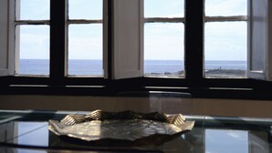 A view through a window with a clear sky and the sea visible.