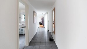A narrow hallway with a tiled floor, leading to a bathroom with a sink and cabinets. - Nice and big 1 BR flat city center/near lake (D8) (Zürich)