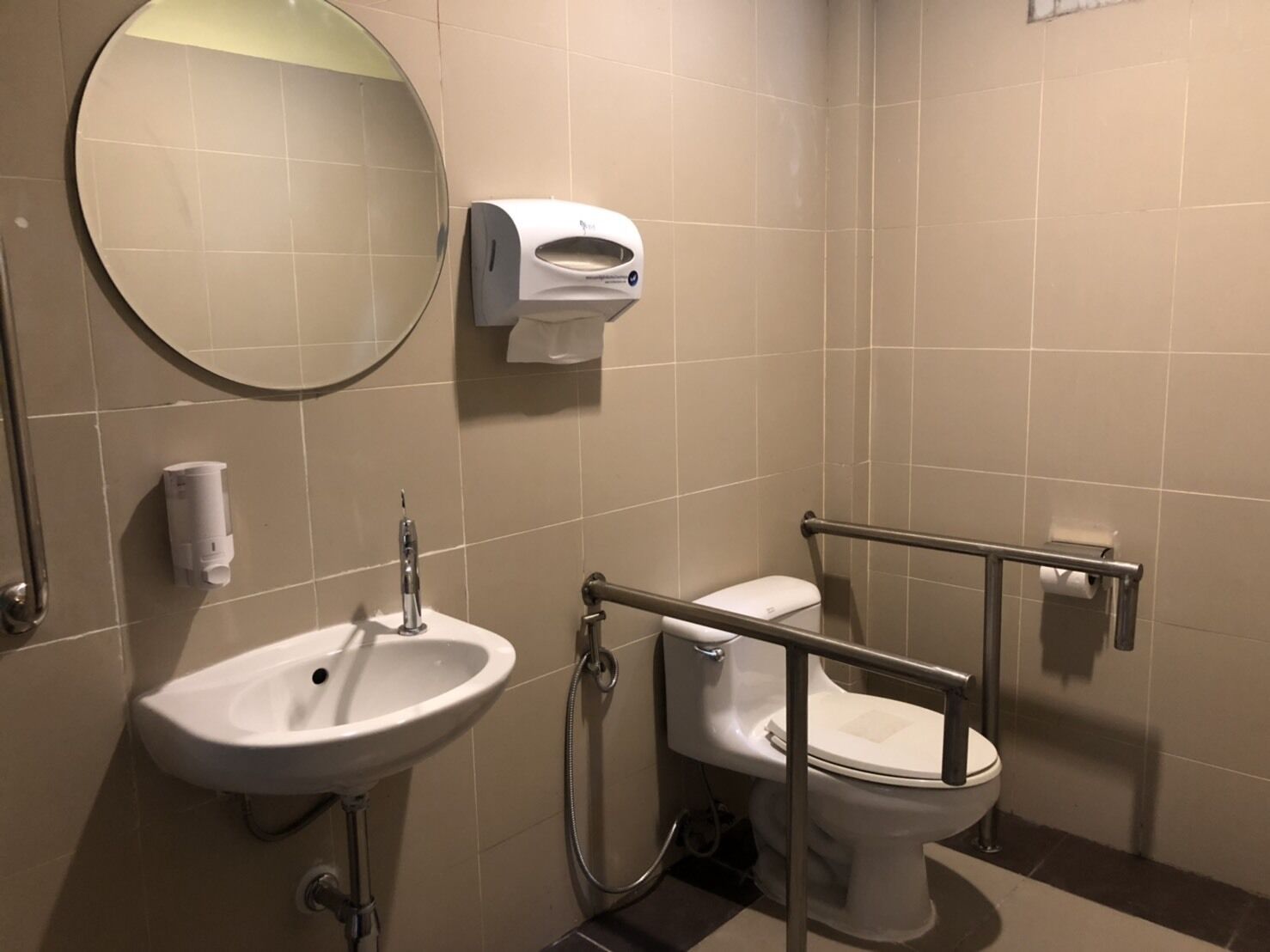 A bathroom with a sink, toilet, and hand dryer.