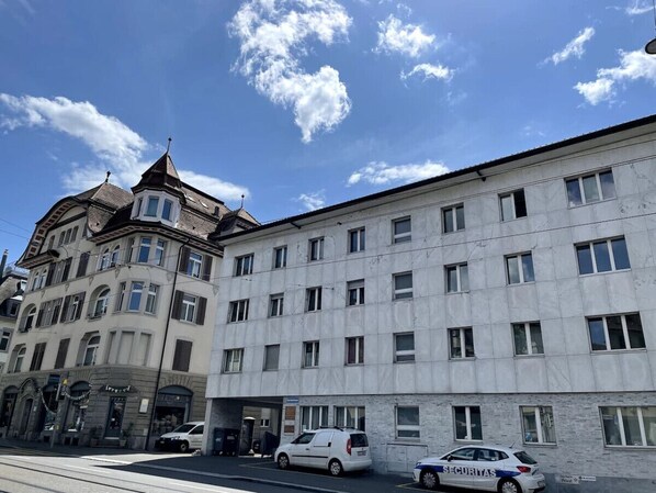 A multi-story building with a mix of architectural styles, including a corner building with a turret and a modern facade.
