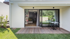 Une maison moderne dotée d’un patio, d’une porte-fenêtre coulissante donnant sur un espace intérieur aménagé avec un canapé et une table à manger.
