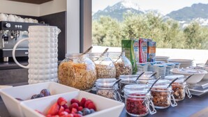 Un buffet de petit-déjeuner proposant une variété de céréales, de fruits et de produits laitiers.