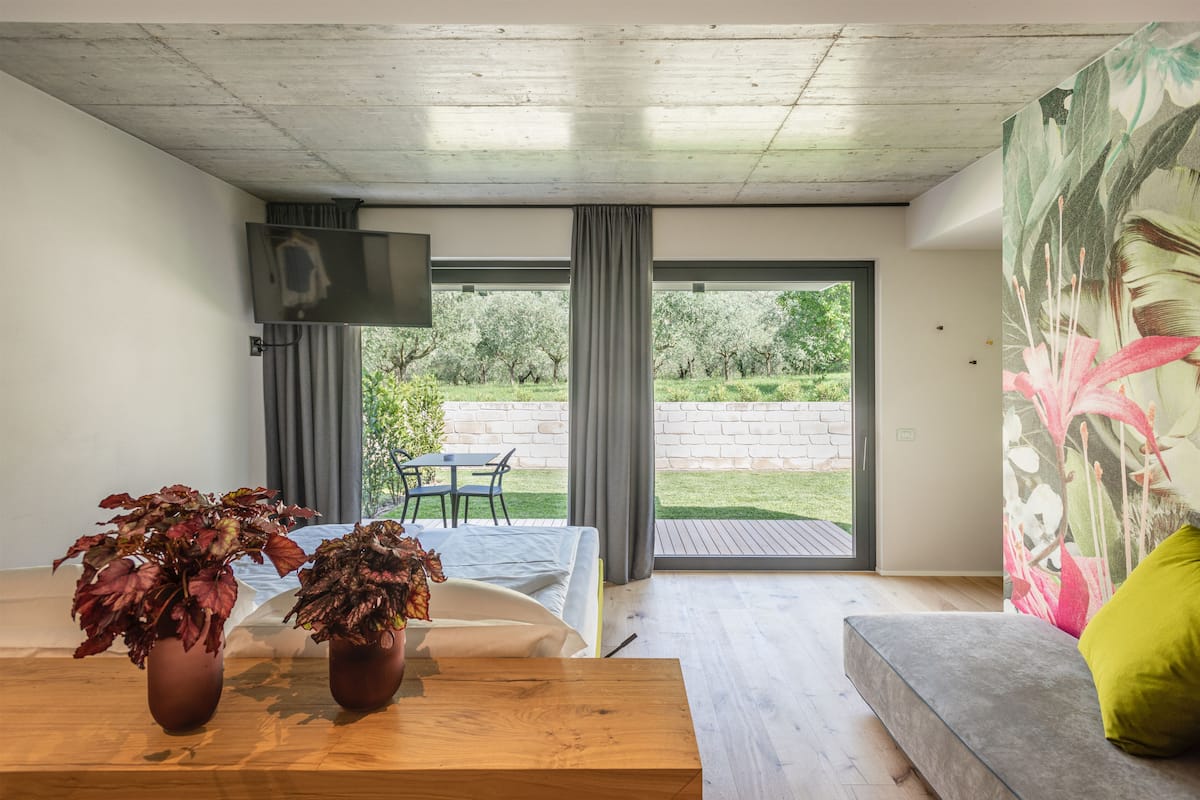 Un salon moderne avec un canapé, une table en bois et deux plantes en pot.