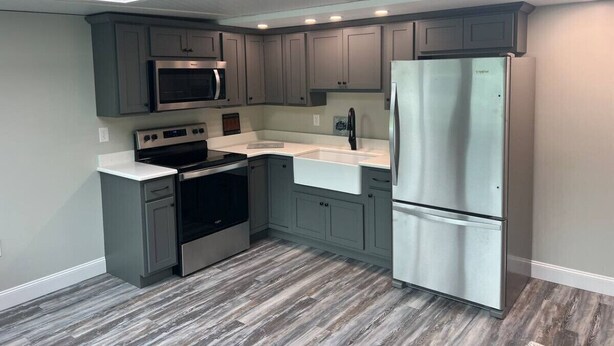 A modern kitchen with grey cabinets, stainless steel appliances, and a skylight. - Sunny 1BR w/ Game Room + Firepit | 10 min to Town (Wellsboro)