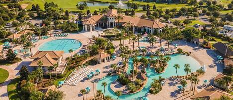 A resort with multiple swimming pools, a golf course, and residential areas in the background.