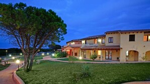 A row of Mediterranean-style villas with terracotta roofs, a well-maintained lawn, and a paved driveway. - Residence with pool in Vignola Mare  (Aglientu)