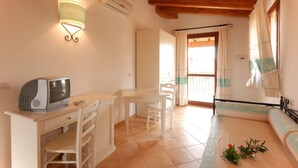 A room with a wooden ceiling, a white desk with a computer, a white chair, a small table, and a sofa. - Residence with pool in Vignola Mare  (Aglientu)