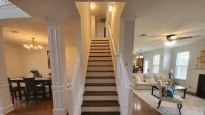 Un escalier avec des rampes blanches menant à l’étage supérieur.