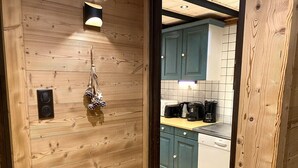 Un intérieur en bois avec un coin cuisine doté de meubles de couleur turquoise, d’un lave-vaisselle Bosch et d’une machine à café.