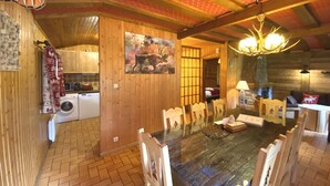 A rustic wooden interior with a dining area, kitchen, and laundry room.