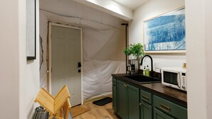 A kitchen with a sink, microwave, and green cabinets. - “Climber's Den” Rare Cliffside Stay w/ HotTub RRG (Campton)