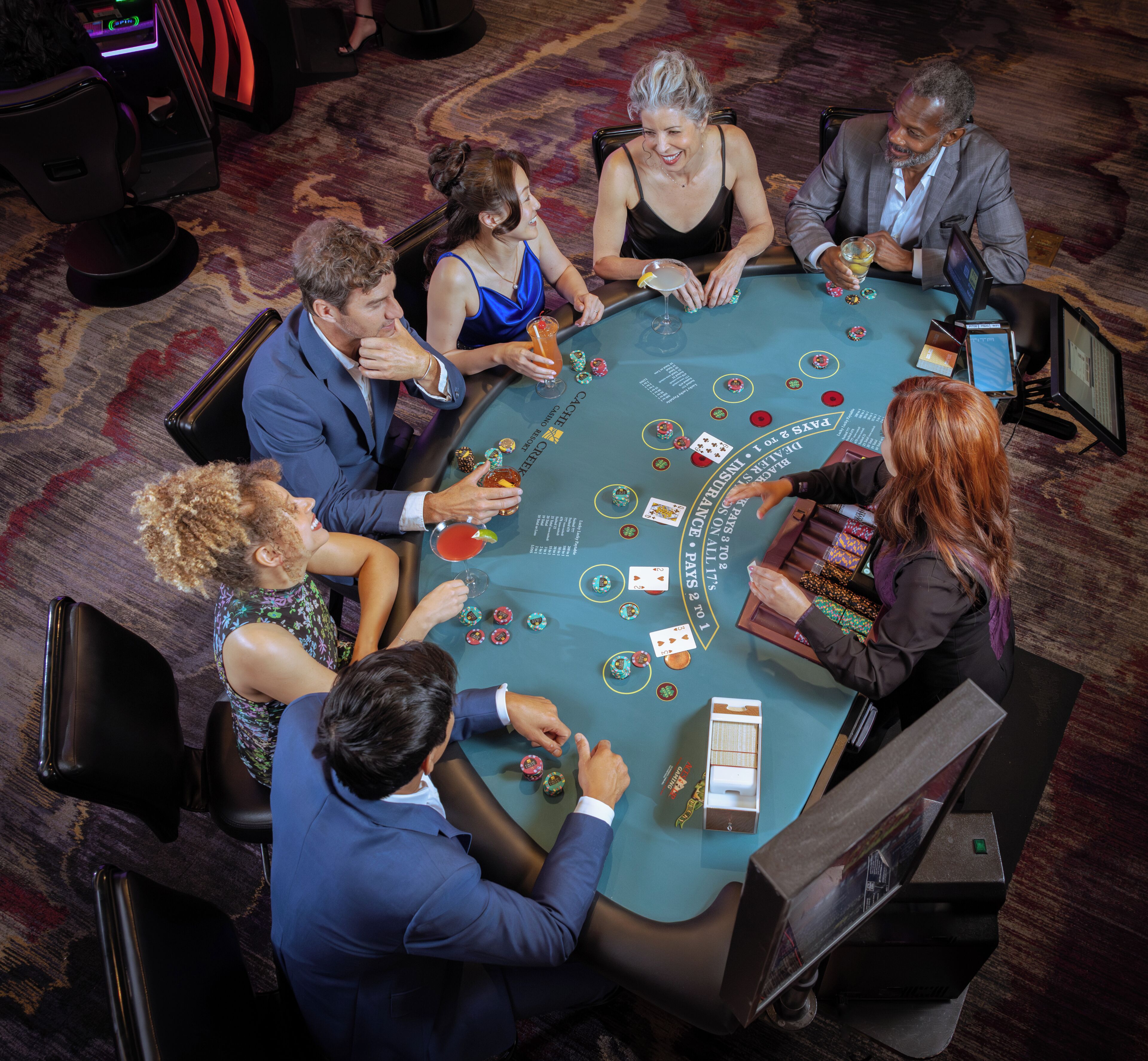 A group of people playing blackjack at a casino table.
