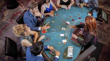 A group of people playing blackjack at a casino table.