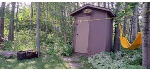 Relax in a secluded setting surrounded by tall trees and a hammock for leisure.