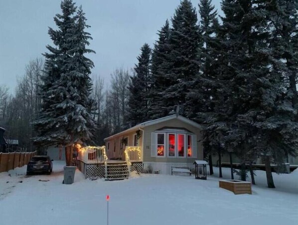 Cozy cabin-style home with a welcoming front porch and inviting windows.
