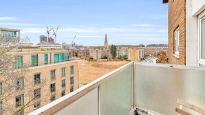 Blick vom Balkon auf eine Baustelle, im Hintergrund ein Kirchturm.