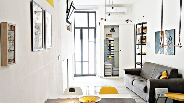 A modern living room with a dining area, featuring a sofa, a table with chairs, and artwork on the walls. - Aurelio's Artpartment - "Unconventional House" (Siracusa)