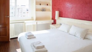 A hotel room with a bed, a window, a white wardrobe, and a red wall. - Spectacular Five Senses Mallorca Apartment (Barcelona)