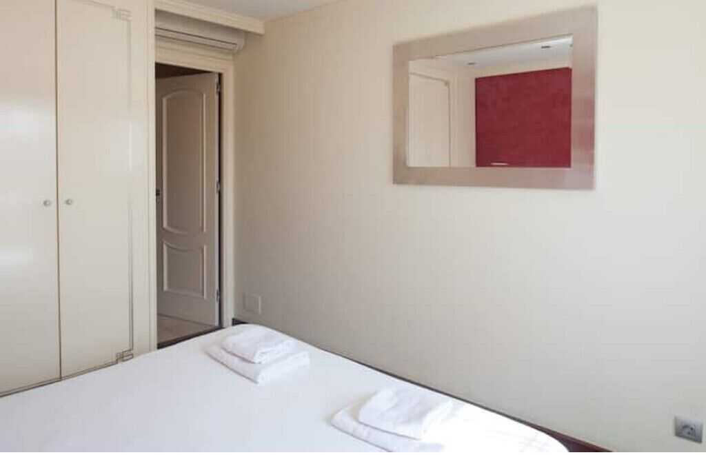 Una camera d'albergo con un letto, un armadio e uno specchio.
