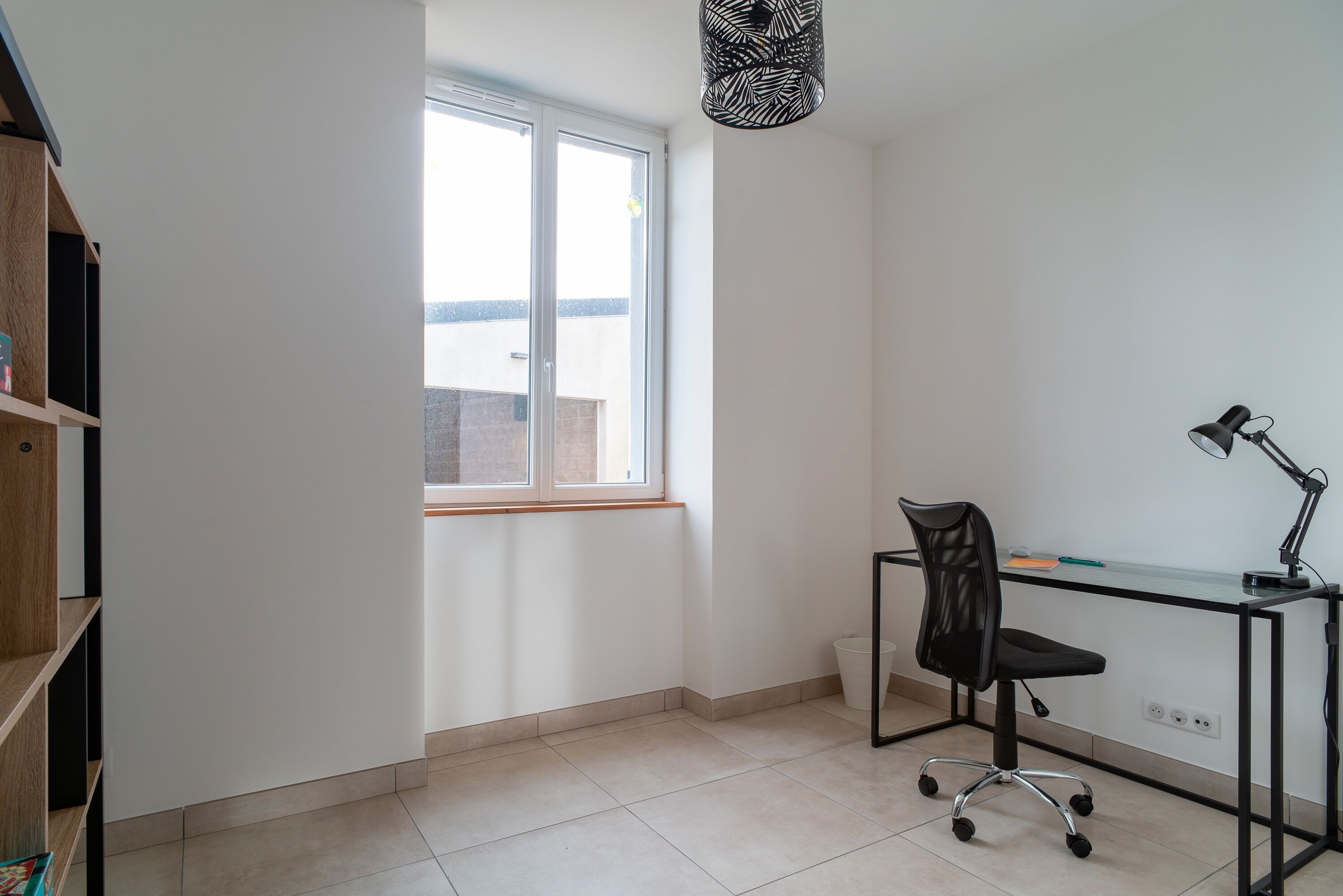 A small office space with a desk, chair, and a window.