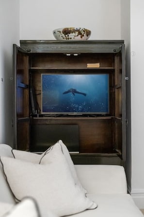 A television set on a wooden stand with a bowl on top. - Luxury lower ground floor apt near King’s Road (London)