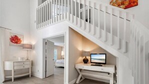 A modern interior with a white staircase, a desk with a computer, and a bed in the background. - CENTRALLY located house. (Naples)