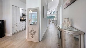 A modern kitchen with white cabinetry, a central island, and a dining area with a glass table. - CENTRALLY located house. (Naples)