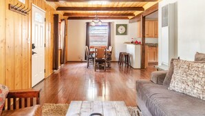 A wooden interior with a dining area, kitchen, and seating area.