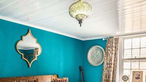 A bedroom with a bed, a mirror, a guitar, and a window with curtains. - Old Post Office - Large house with games room +bar (Ramsgate)