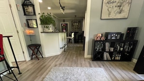 A spacious living area with a large shaggy rug, wooden flooring, and a kitchen area in the background. - 3-bedroom vacation home just 2 minutes to Lake Michigan (Traverse City)