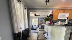 A kitchen with a central island, wooden flooring, and a ceiling fan. - 3-bedroom vacation home just 2 minutes to Lake Michigan (Traverse City)