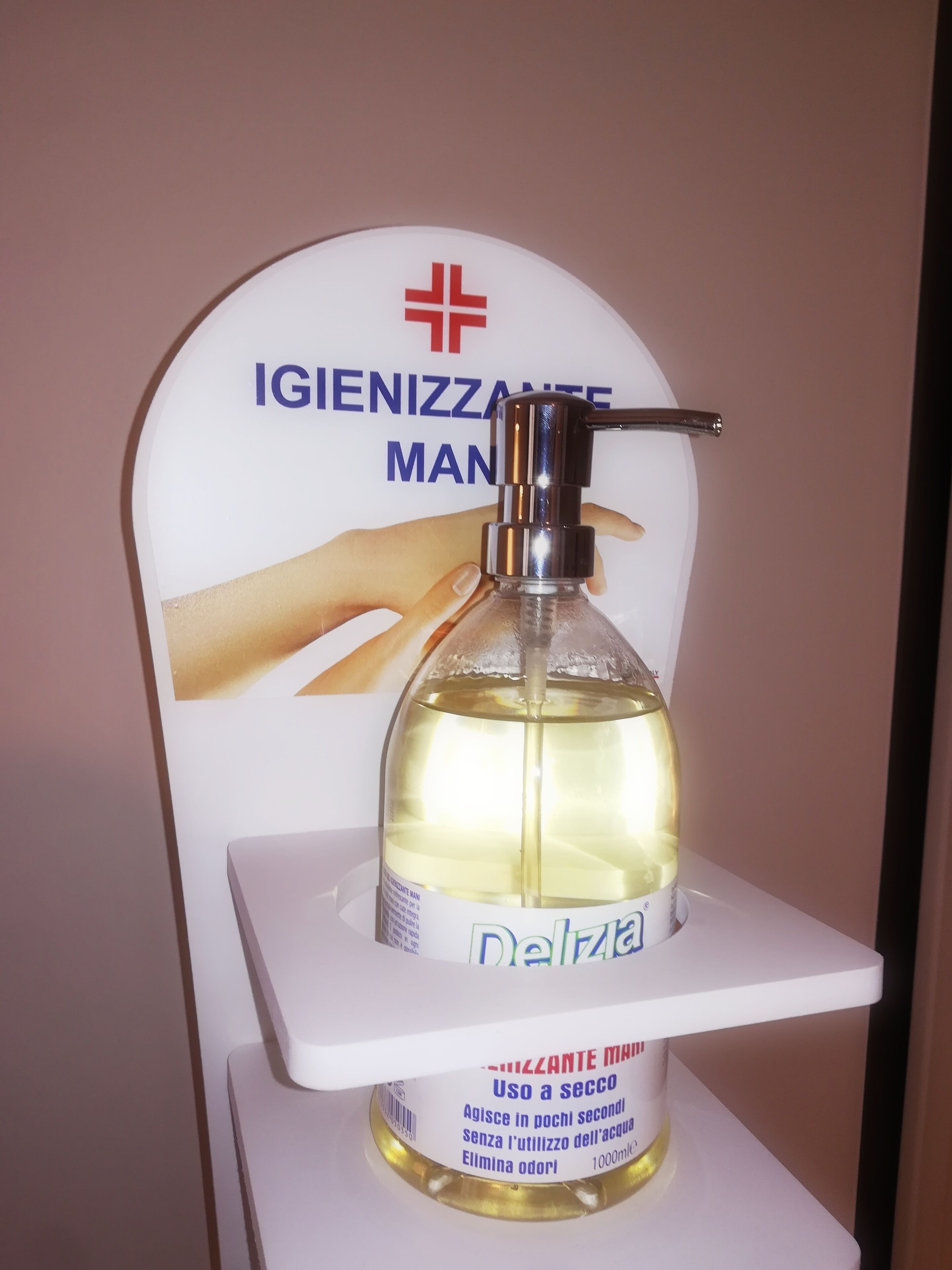 Um dispensador de álcool em gel com etiqueta que diz 'Delizal' e instruções de uso.