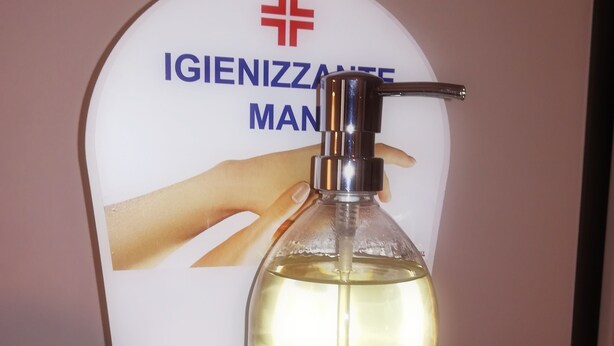 Dispensador de gel antibacterial con una etiqueta que dice "Delizal" e instrucciones de uso.