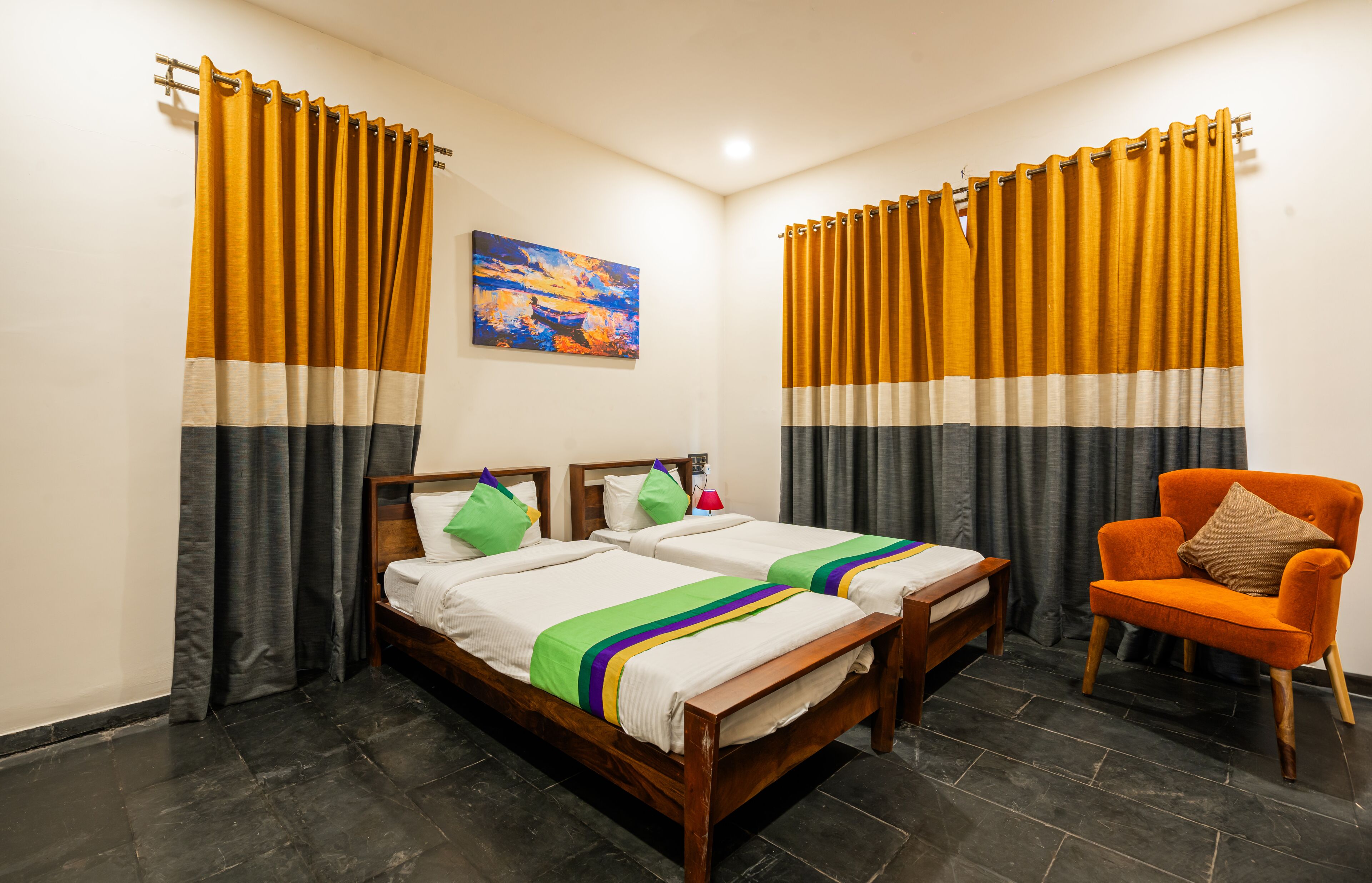 Una habitación con dos camas de madera, una mesita de noche, una silla y cortinas.