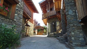Ein traditionelles Steinhaus mit hölzernen Balkonen und einem Kiesweg.
