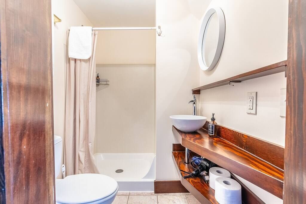 Une salle de bain avec des toilettes, un lavabo et une douche.