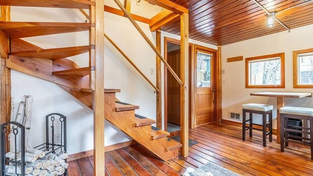 A wooden staircase leading to a loft bedroom with a view of the outdoors. - Charming two-level retreat (Seattle)