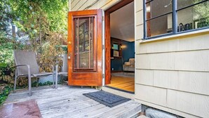 A wooden deck with a door leading to a room with a window. - Charming 1bd Suite in Cap Hill - With Parking (Seattle)