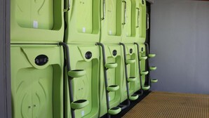 A row of green lockers with handles and a control panel, likely for storing personal items. - Pupa House  (Tamarindo)