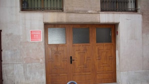 A large wooden door with a sign indicating it is an external apartment.
