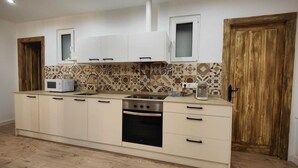 A modern kitchen with light-colored cabinets, a patterned backsplash, and a built-in oven.
