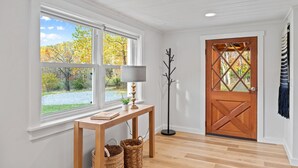 A room with a wooden floor, a window with a view of autumn trees, a wooden door, and a floor lamp. - Hot Tub*Borders National Park*Near Massanutten Resort*42 Acres*Private (Elkton)