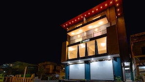 Un edificio de varios pisos con un llamativo letrero que dice 'treehouse', ventanas amplias y un balcón con luces.